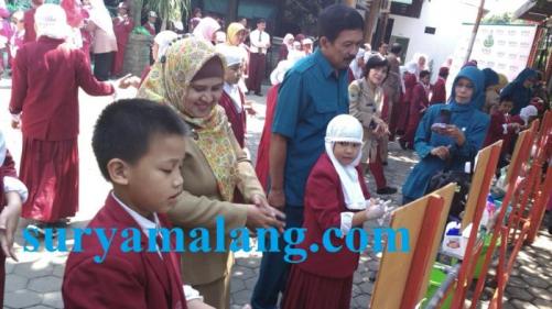 Siswa SD Unggulan Al Ya`lu saat praktek cuci tangan yang benar dipandu staff Dinas Kesehatan Kota Malang, Senin (3/7/2015. Surya) .