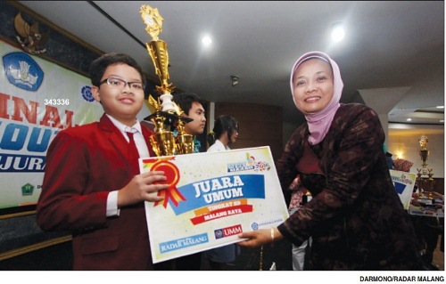 SELAMAT YA..: Muhammad Shabri menerima trofi dari Kabid Sekolah Menengah Disdik Kabupaten Malang Puji Hariwati di Dome UMM, Minggu 20/3/2016 lalu.
